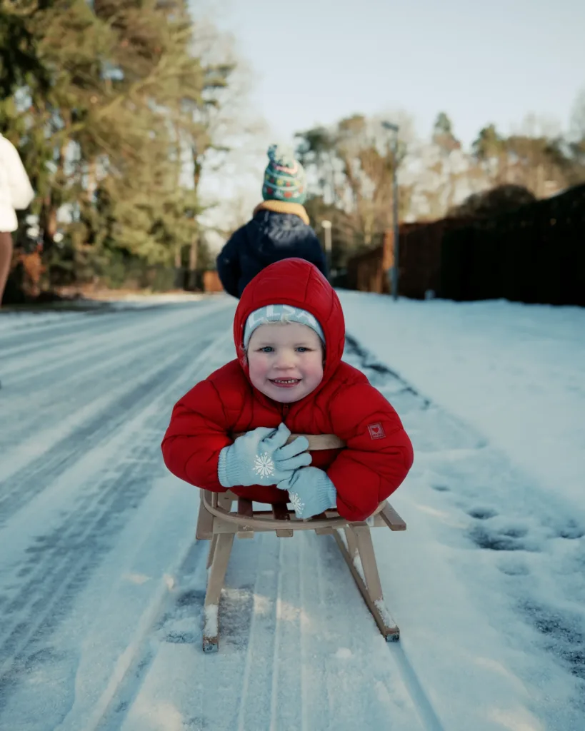 child sledding winter road